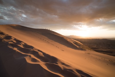 黎明时分一群人在沙漠上行走